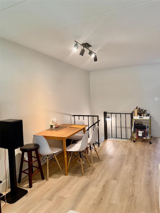 dining room with wood finished floors and rail lighting