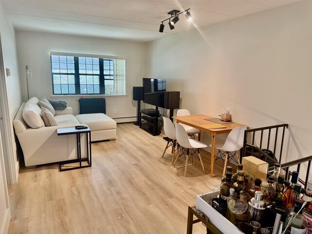 living area featuring a baseboard heating unit, light wood-style floors, and rail lighting