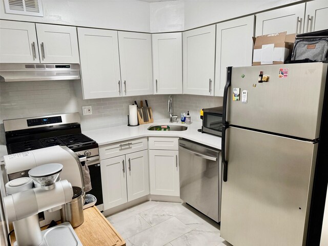 kitchen featuring stainless steel appliances, a sink, visible vents, light countertops, and under cabinet range hood