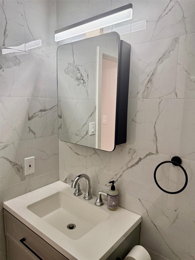bathroom featuring tile walls, vanity, and tasteful backsplash