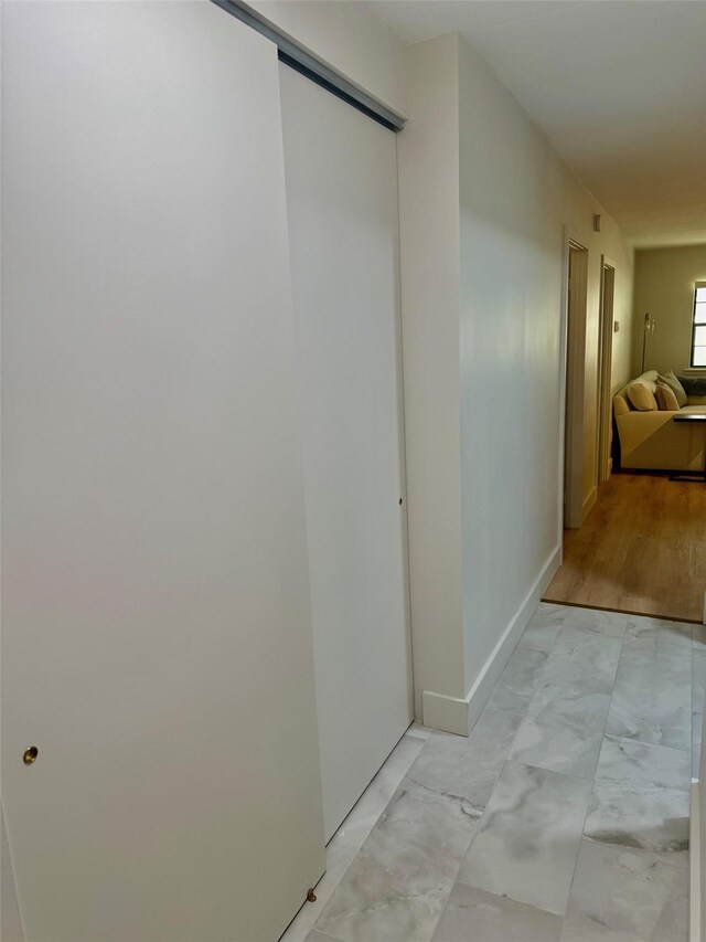 hall featuring baseboards and marble finish floor