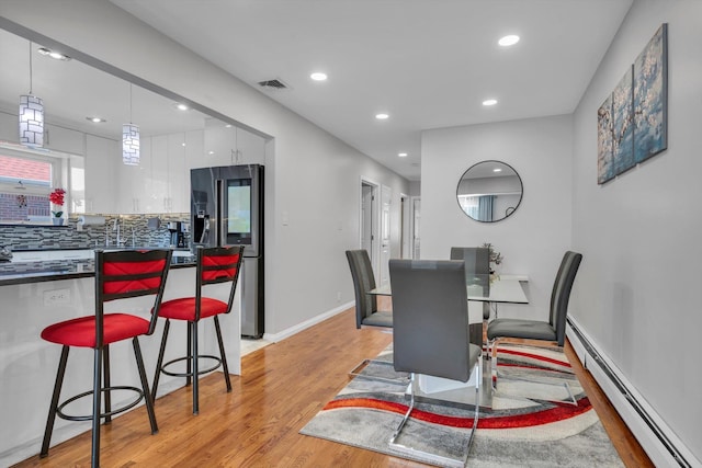 143-07 Rose Ave, Flushing, NY 11355 - dining area featuring a baseboard heating unit, recessed lighting, light wood-style floors, and baseboards