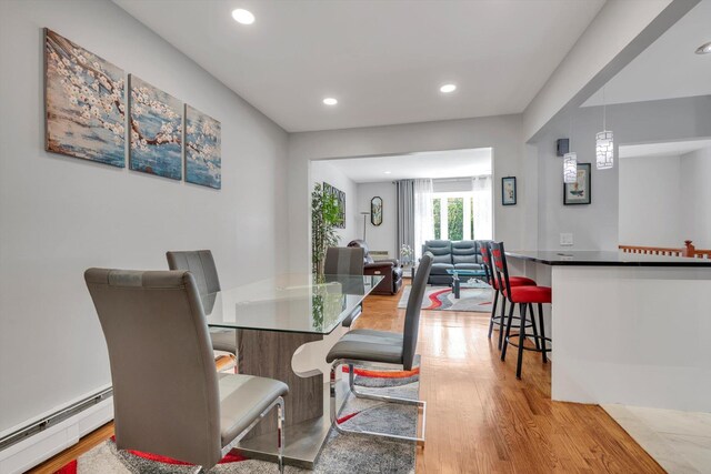 143-07 Rose Ave, Flushing, NY 11355 - dining space featuring a baseboard heating unit, light wood-style floors, and recessed lighting