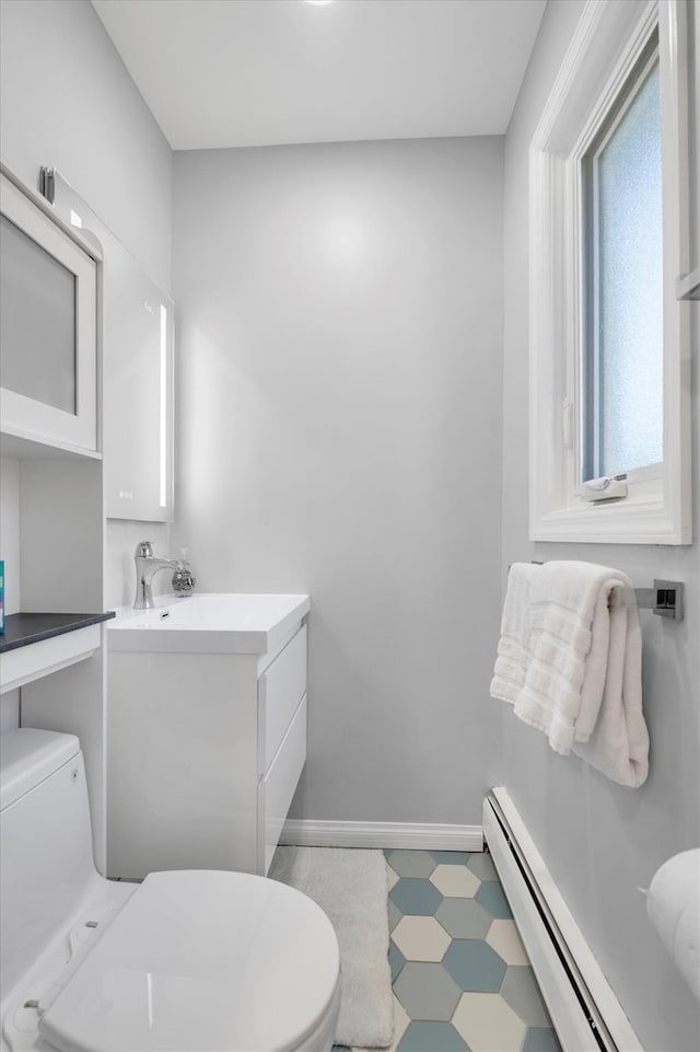 143-07 Rose Ave, Flushing, NY 11355 - bathroom featuring baseboard heating, toilet, tile patterned floors, vanity, and baseboards