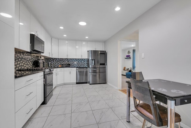 143-07 Rose Ave, Flushing, NY 11355 - kitchen featuring black appliances, dark countertops, light marble finish flooring, modern cabinets, and white cabinetry