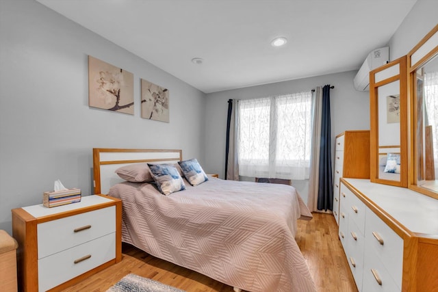 143-07 Rose Ave, Flushing, NY 11355 - bedroom featuring a wall unit AC, light wood-style flooring, and recessed lighting