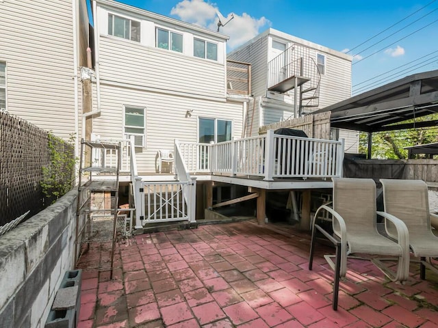 rear view of property featuring a deck, a patio, and a fenced backyard