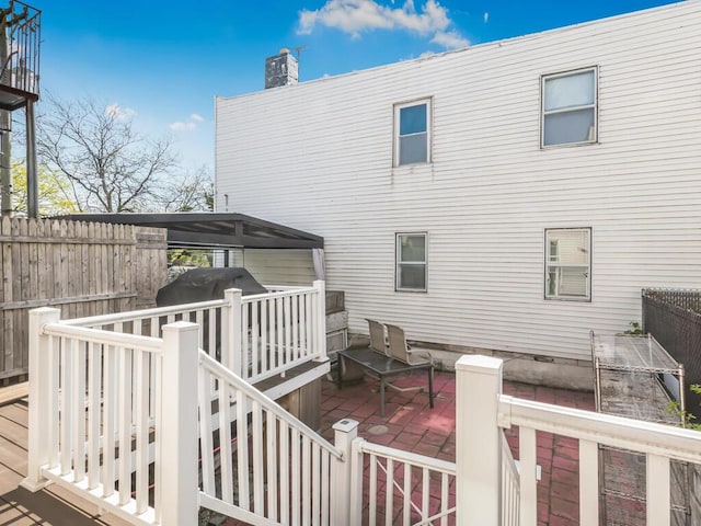rear view of property with a chimney, fence, a gazebo, a patio, and a wooden deck