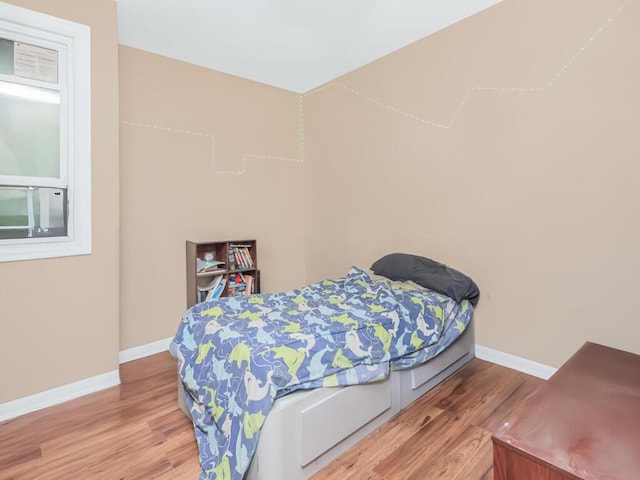 bedroom with light wood finished floors and baseboards