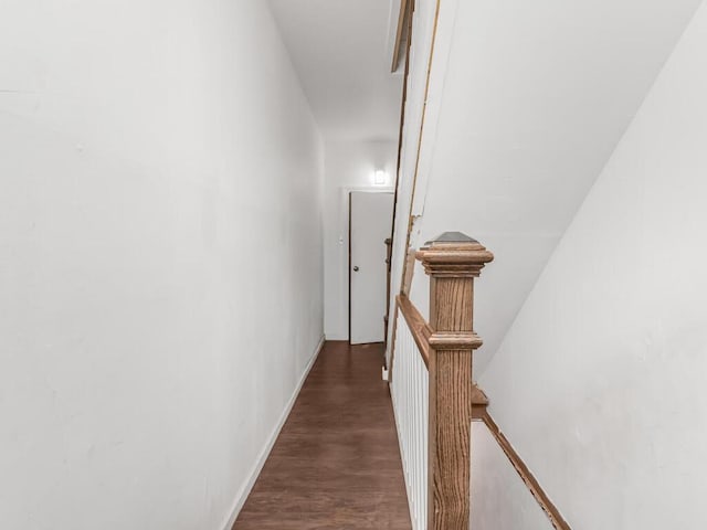 corridor featuring wood finished floors and an upstairs landing