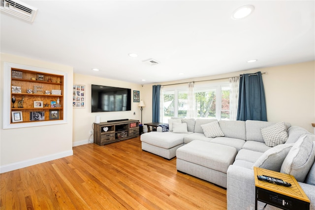 living room with recessed lighting, light wood-style flooring, and visible vents