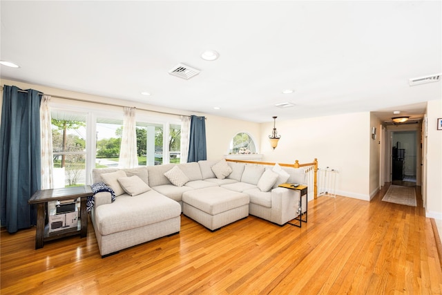 living room featuring light wood-style floors, baseboards, recessed lighting, and visible vents