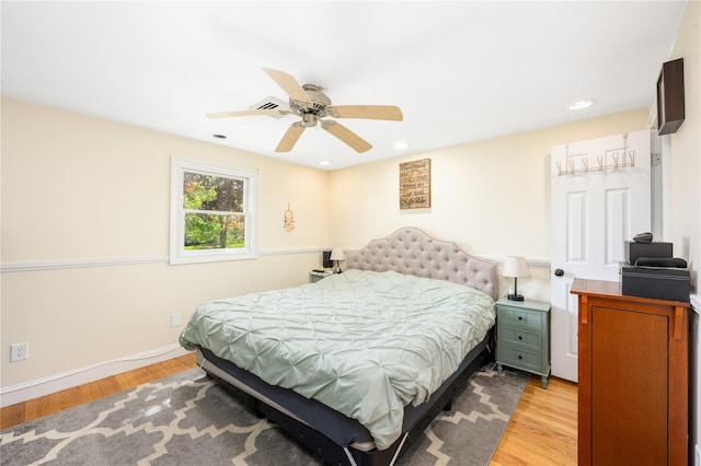 bedroom with baseboards, a ceiling fan, and light wood-type flooring