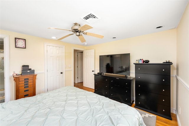 bedroom with visible vents, baseboards, ceiling fan, and wood finished floors