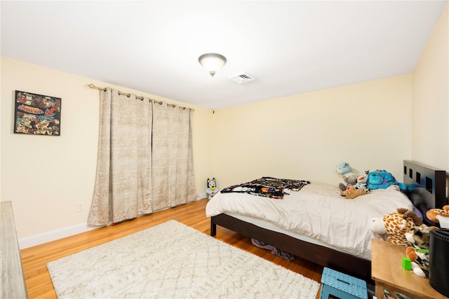 bedroom featuring visible vents, wood finished floors, and baseboards