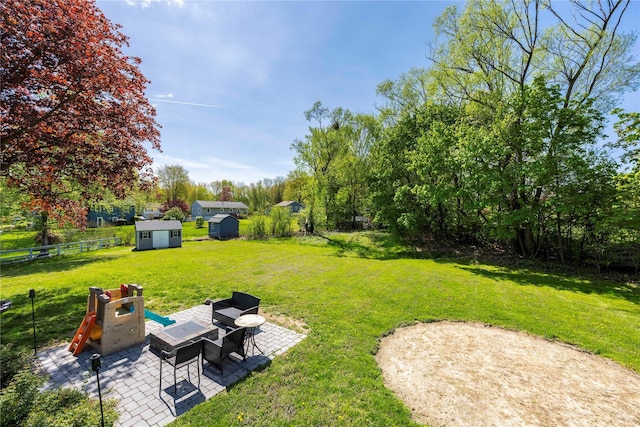 view of yard featuring a patio, fence, an outbuilding, and a storage unit