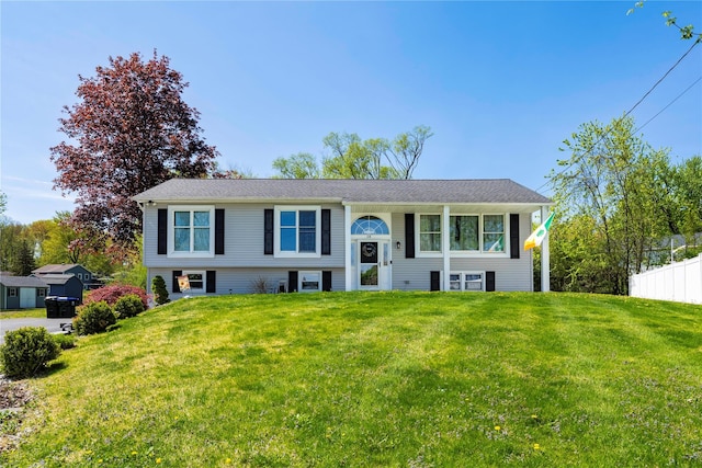 raised ranch with fence and a front lawn