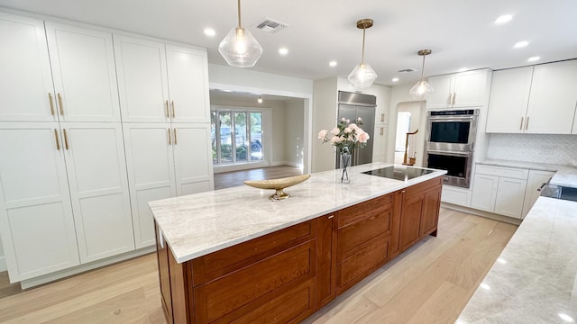 kitchen with light wood-type flooring, stainless steel double oven, and recessed lighting