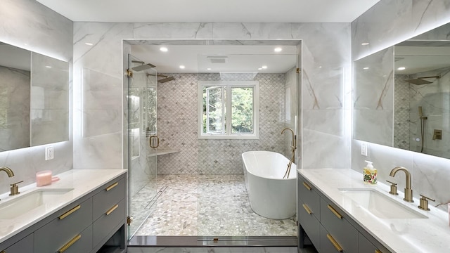 bathroom featuring two vanities, a stall shower, and a sink