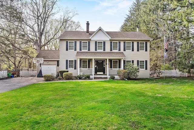 colonial-style house with a chimney, a porch, fence, driveway, and an attached garage