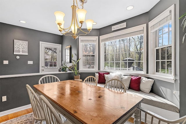 dining area with baseboards, recessed lighting, wood finished floors, and a notable chandelier