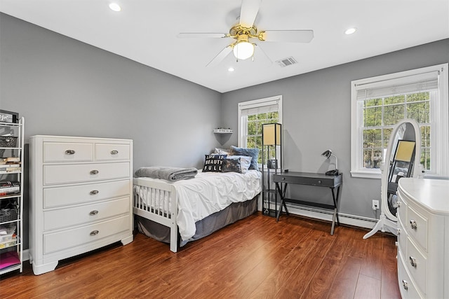 bedroom featuring a baseboard heating unit, dark wood-style floors, recessed lighting, and visible vents