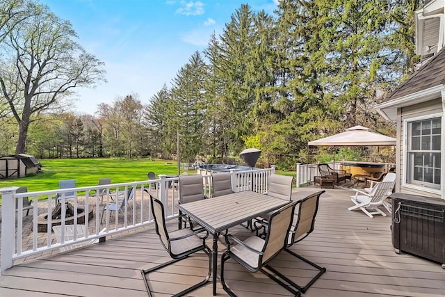 wooden terrace with outdoor dining space, a yard, a storage shed, and an outdoor structure