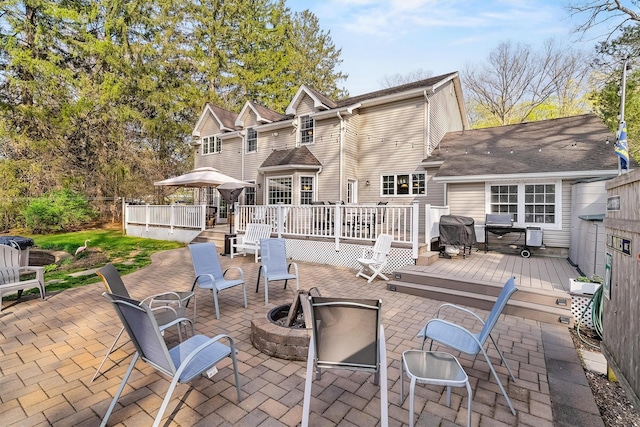 back of property featuring a fire pit, a patio, and a wooden deck
