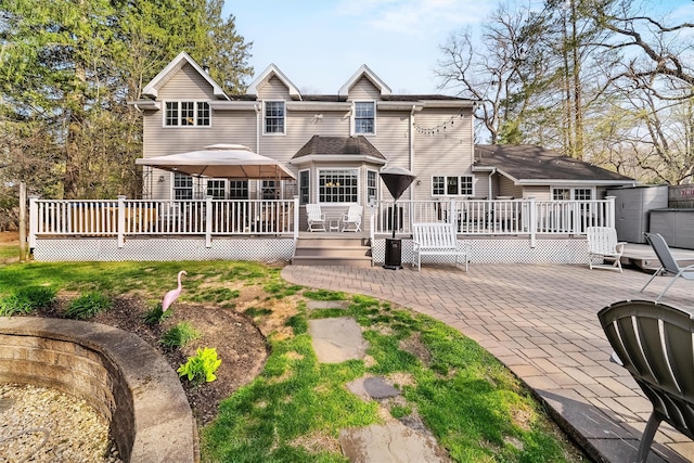 back of property with a deck, a patio, and central air condition unit