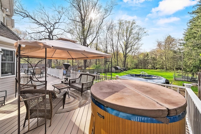 deck featuring a yard, a gazebo, and a hot tub
