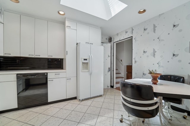 103 S Nauraushaun Rd, Pearl River, NY 10965 - kitchen featuring a skylight, white refrigerator with ice dispenser, wallpapered walls, black dishwasher, and white cabinetry