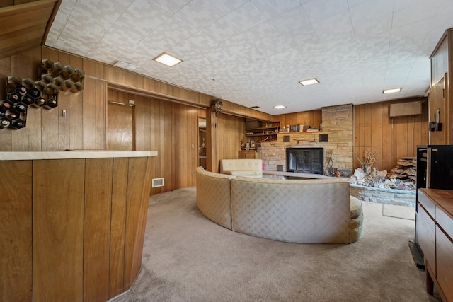103 S Nauraushaun Rd, Pearl River, NY 10965 - living room with wood walls, carpet, visible vents, and a stone fireplace