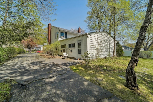 103 S Nauraushaun Rd, Pearl River, NY 10965 - view of home's exterior featuring a chimney and fence