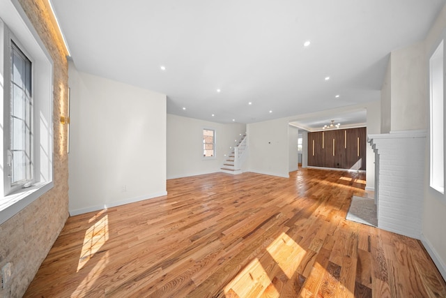 13107 229th St, Laurelton, NY 11413 - unfurnished living room featuring baseboards, recessed lighting, stairs, and light wood-style flooring