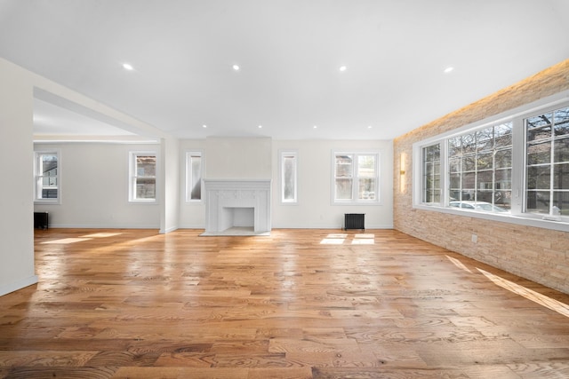 13107 229th St, Laurelton, NY 11413 - unfurnished living room featuring baseboards, wood finished floors, and a healthy amount of sunlight