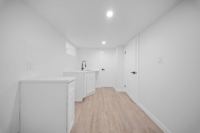 13107 229th St, Laurelton, NY 11413 - laundry room with recessed lighting, baseboards, a sink, and light wood-style floors