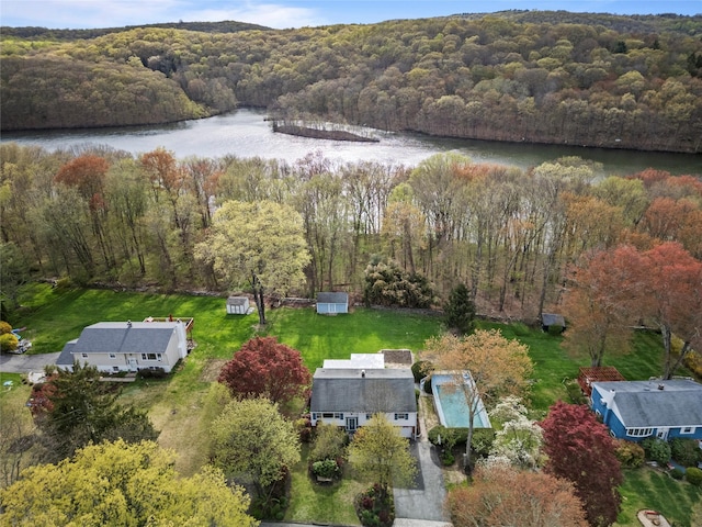 drone / aerial view featuring a water view and a wooded view