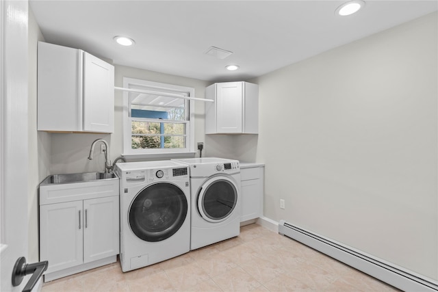clothes washing area with recessed lighting, a sink, cabinet space, washer and dryer, and baseboard heating