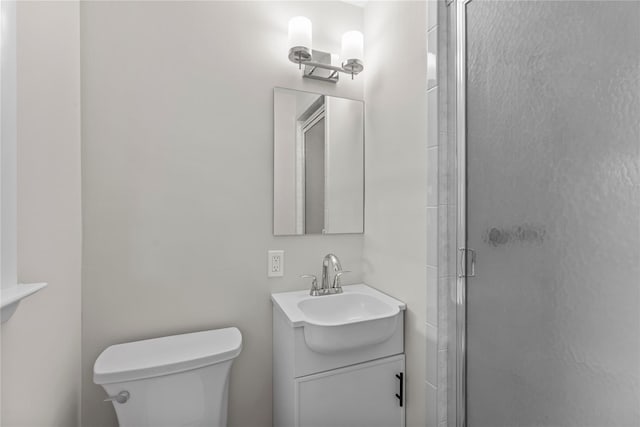 full bathroom with a shower stall, toilet, and vanity