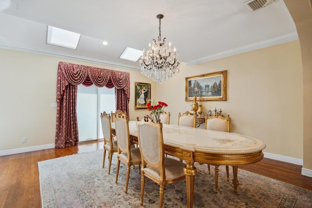 44 Netz Pl, Albertson, NY 11507 - dining area featuring wood finished floors, a skylight, a chandelier, ornamental molding, and baseboards