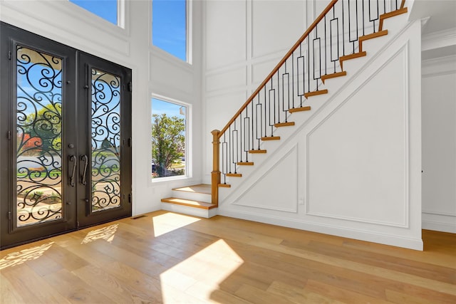 entrance foyer with a decorative wall, french doors, and stairs