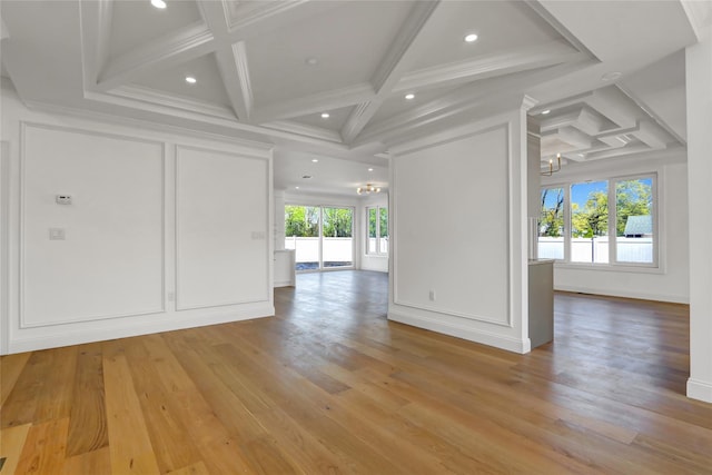 unfurnished room with a chandelier, light wood-type flooring, beamed ceiling, and coffered ceiling