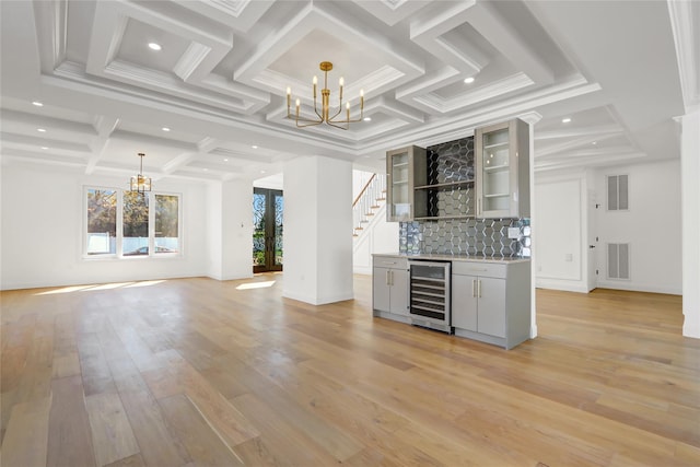 interior space with beverage cooler, coffered ceiling, visible vents, a dry bar, and a chandelier