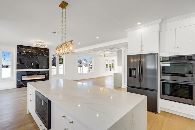 kitchen featuring white cabinets, visible vents, light wood-style flooring, appliances with stainless steel finishes, and open floor plan