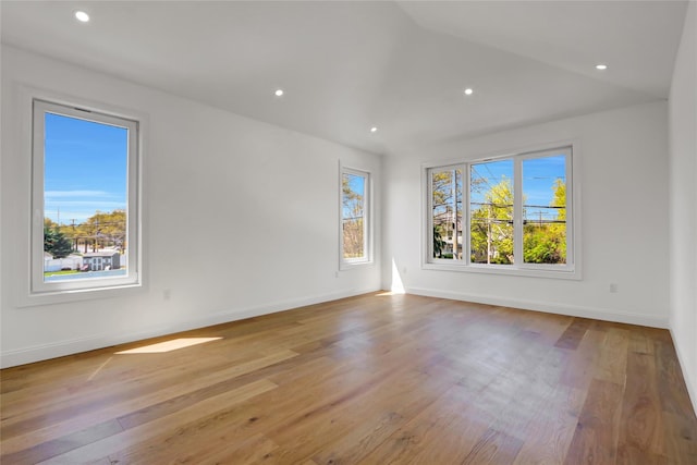 spare room featuring baseboards, lofted ceiling, wood finished floors, and recessed lighting