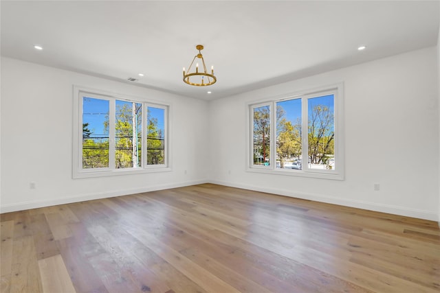 unfurnished room with wood finished floors, baseboards, recessed lighting, and a chandelier