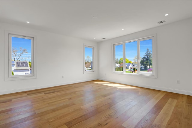 empty room with recessed lighting, light wood-style floors, visible vents, and baseboards