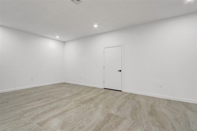 spare room featuring baseboards, visible vents, and recessed lighting