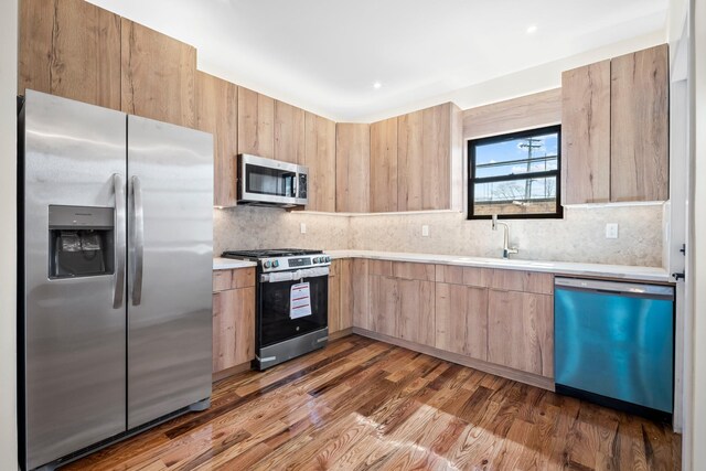 22518 Mentone Ave, Laurelton, NY 11413 - kitchen with light countertops, light brown cabinets, a sink, tasteful backsplash, and appliances with stainless steel finishes