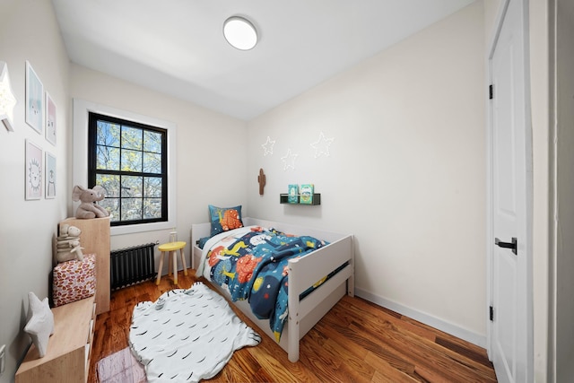 22518 Mentone Ave, Laurelton, NY 11413 - bedroom with radiator, wood finished floors, and baseboards